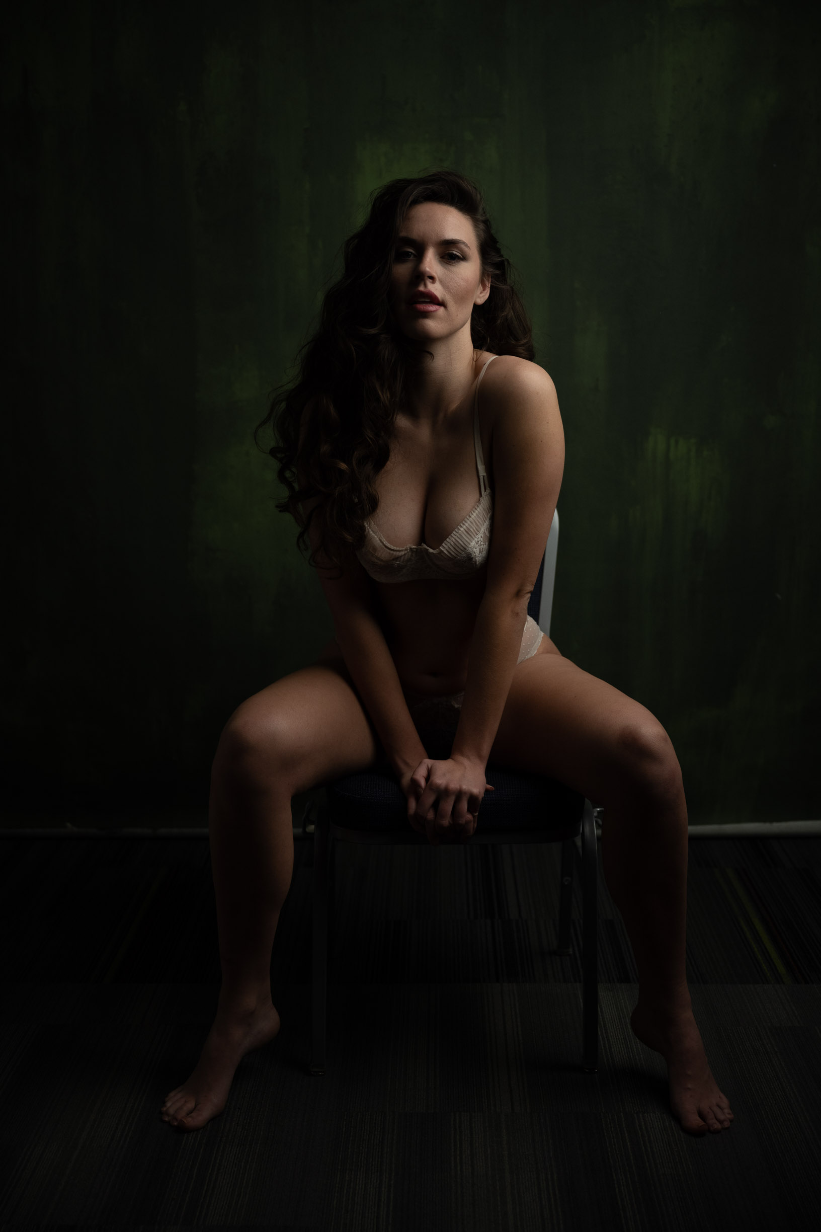 boudoir portrait of a brunette woman in lingerie seated on a stool